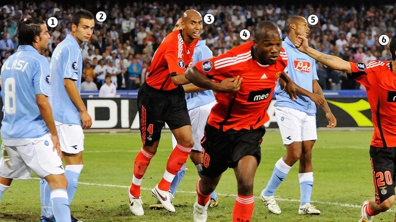 Cầu thủ Benfica giữ bóng trước áp lực từ cầu thủ Napoli trên sân cỏ
